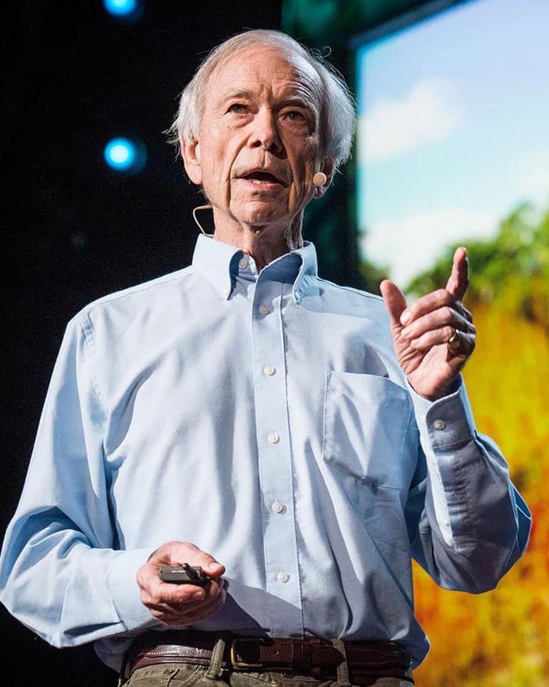 Allan Savory of the Savory Institute speaking on stage to an audience