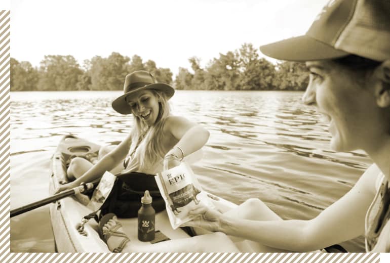 Two women enjoying a bag of EPIC Provisions Bites while kayaking